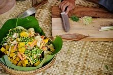 cuts fresh vegetables and other ingredients to make delicious samlor korko soup. 