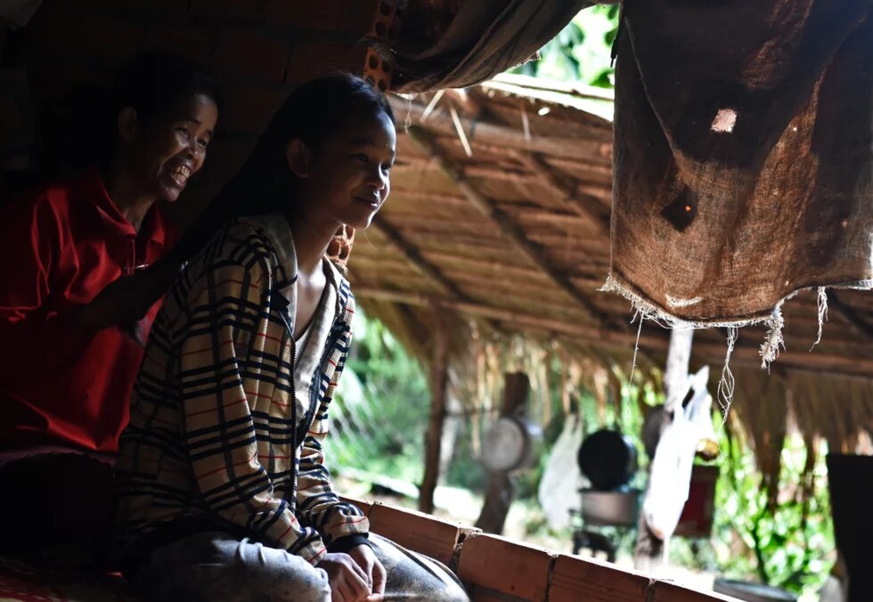 Chhang Kheang braids her daughter’s hair